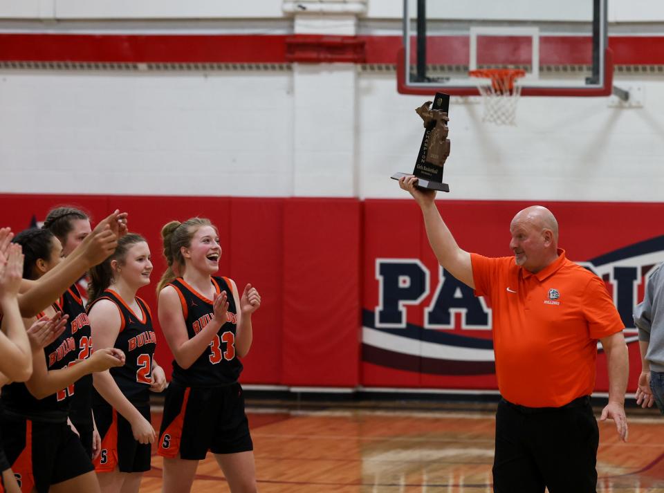 Summerfield girls basketball coach Mickey Moody presents the trophy to his team after a 67-45 win over Britton Deerfield in the finals of the Division 4 District at Britton Deerfield Saturday.