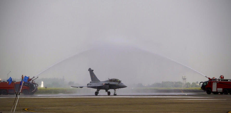 Water is sprayed on a French-made Rafale fighter jet during its induction ceremony at the Indian Air Force Station in Ambala, India, Thursday, Sept.10, 2020. The first batch of five planes, part of a $8.78 billion deal signed between the two countries in 2016 had arrived here in July. (AP Photo/Manish Swarup)