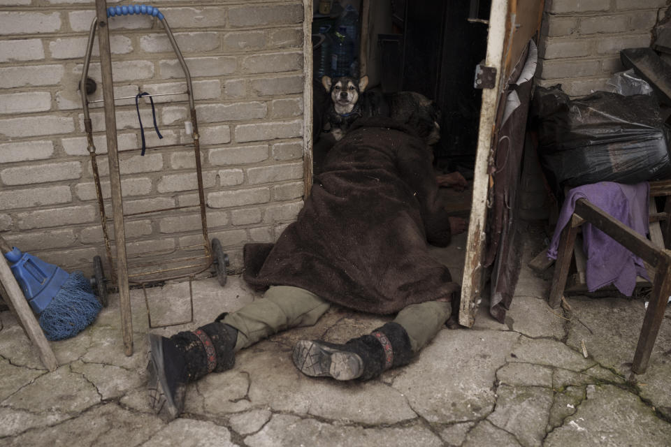 FILE - A dog stands next to the body of an elderly woman killed at the entrance of her house in Bucha, on the outskirts of Kyiv, Ukraine, Tuesday, April 5, 2022. Ministers from dozens of nations are meeting on Thursday, July 14, 2022 in the Netherlands to discuss with the International Criminal Court’s chief prosecutor how best to coordinate efforts to bring to justice perpetrators of war crimes in Ukraine. (AP Photo/Felipe Dana, File)