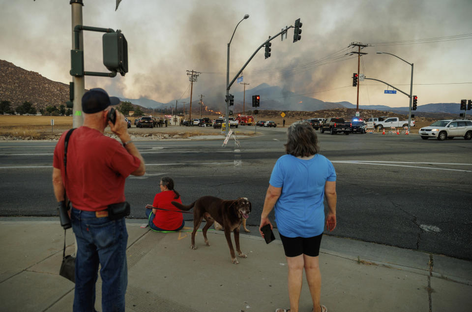 People watch a plume of smoke from the Fairview Fire from a distance Monday, Sept. 5, 2022, near Hemet, Calif. (AP Photo/Ethan Swope)