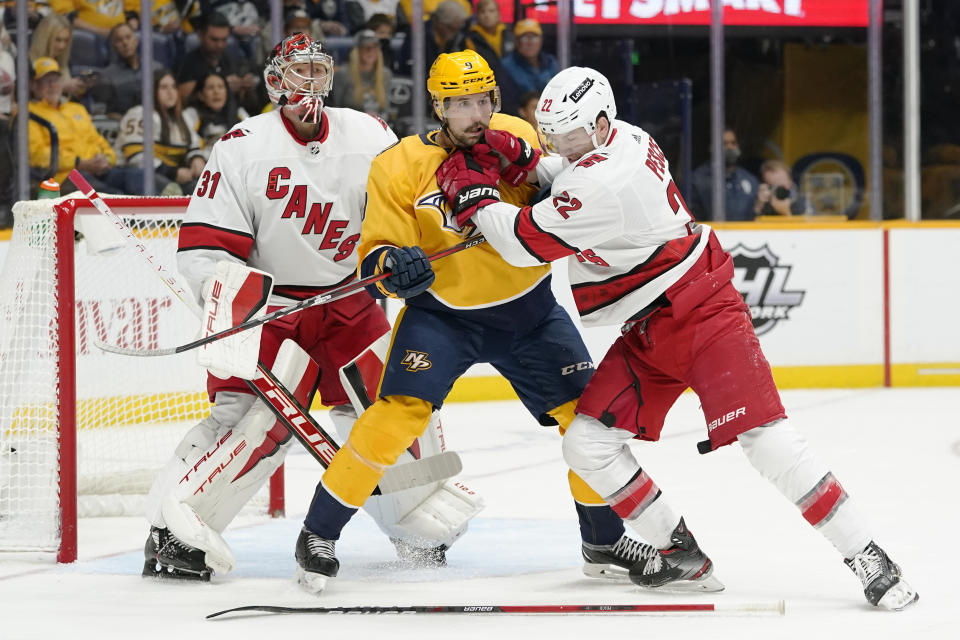 Carolina Hurricanes' Brett Pesce (22) defends against Nashville Predators left wing Filip Forsberg (9) after Pesce dropped his stick in the second period of an NHL hockey game Saturday, Oct. 16, 2021, in Nashville, Tenn. (AP Photo/Mark Humphrey)