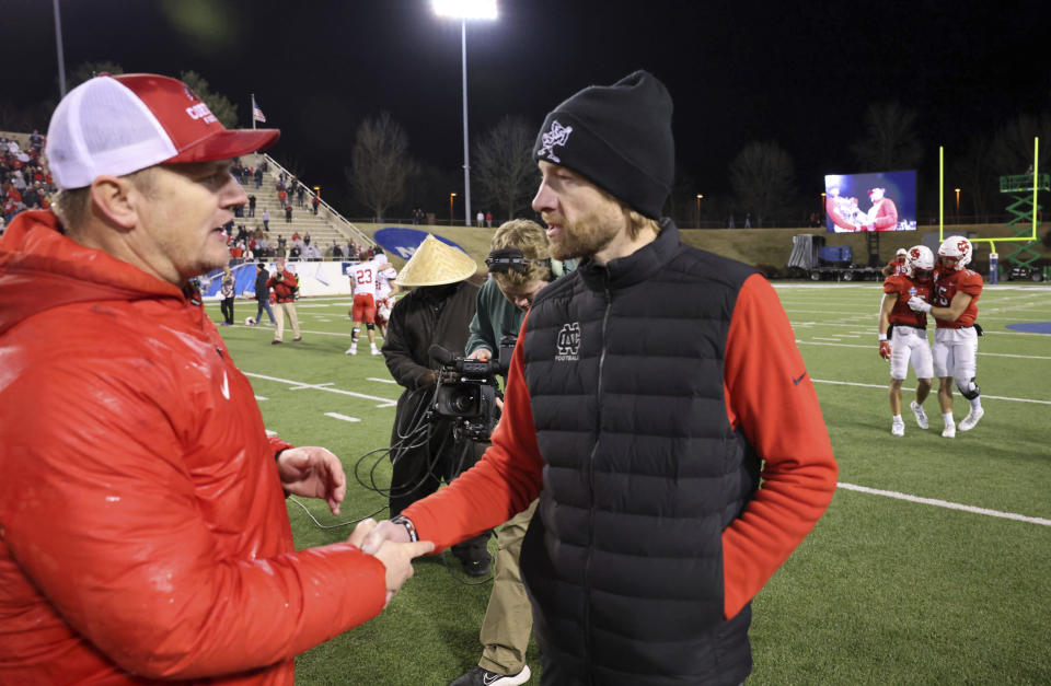 Cortland coach Curt Fitzpatrick, left, and North Central head coach Brad Spencer meet after the Amos Alonzo Stagg Bowl NCAA Division III championship football game in Salem, Va., Friday Dec. 15, 2023. (Matt Gentry/The Roanoke Times via AP)
