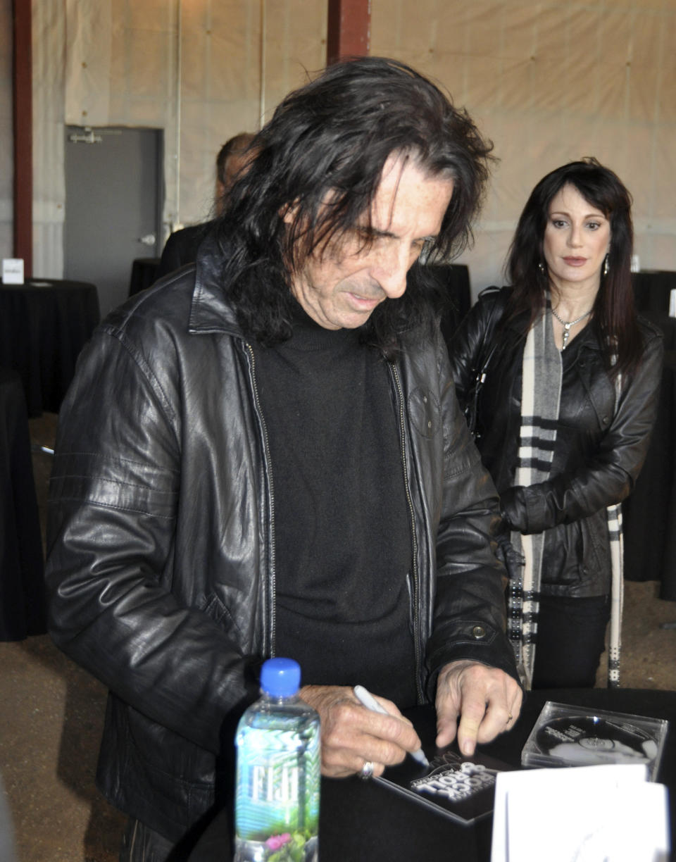 Heavy metal icon Alice Cooper signs a CD as his wife, Sheryl, looks on, Wednesday, Oct. 10, 2012, in Sioux Falls, S.D. Cooper was in South Dakota to help his friend, Dollar Loan Center majority owner Chuck Brennan, open a 6,000-square-foot rock ëní roll academy that will be open exclusively to Boys and Girls Clubs members. (AP Photo/Dirk Lammers)