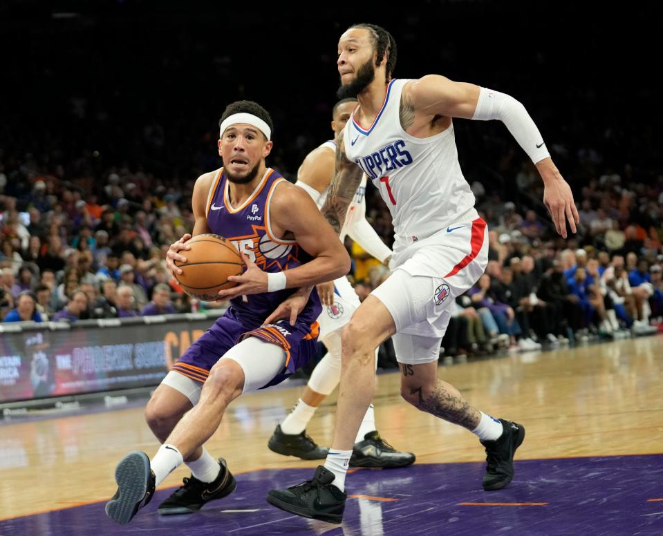Phoenix Suns guard Devin Booker (1) is defended by LA Clippers guard Amir Coffey (7) during the fourth quarter at Footprint Center in Phoenix on April 9, 2024.