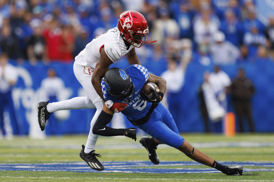 Louisville cornerback Quincy Riley (3) tackles Kentucky wide receiver Dane Key (6) during the first half of an NCAA college football game in Lexington, Ky., Saturday, Nov. 26, 2022. (AP Photo/Michael Clubb)