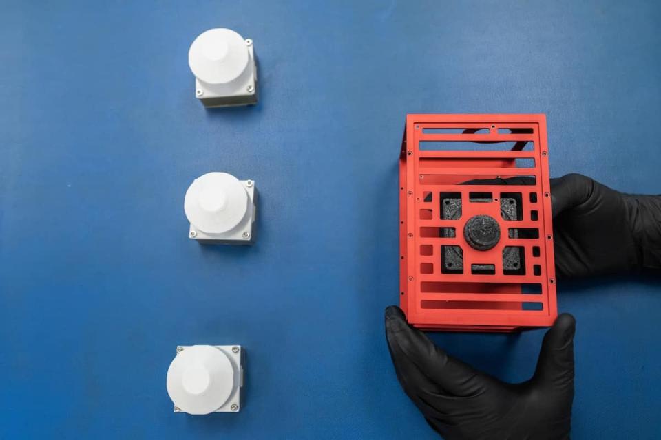 Engineering students in Embry-Riddle's Space Technologies Lab clean room examine the cameras and CubeSat that comprise EagleCam, which is expected to land on the Moon on Feb. 22.