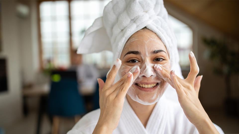 Woman washing her face, which is one of the at home facial steps