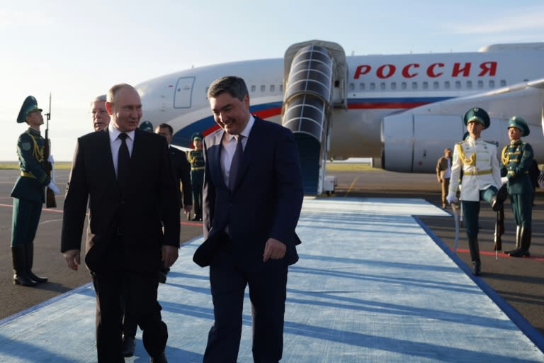 Le président russe Vladimir Poutine (g) accueilli par le Premier ministre kazakh Olzhas Bektenov à son arrivée à l'aéroport d'Astana, le 3 juillet 2024 (Gavriil GRIGOROV)