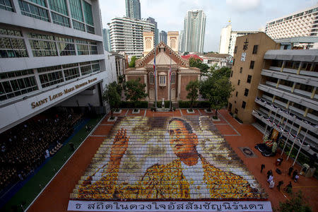 Some 1,250 students from the Assumption College hold cards to form an image of Thailand's late King Bhumibol Adulyadej, in his honour, in Bangkok, Thailand, October 28, 2016. REUTERS/Athit Perawongmetha