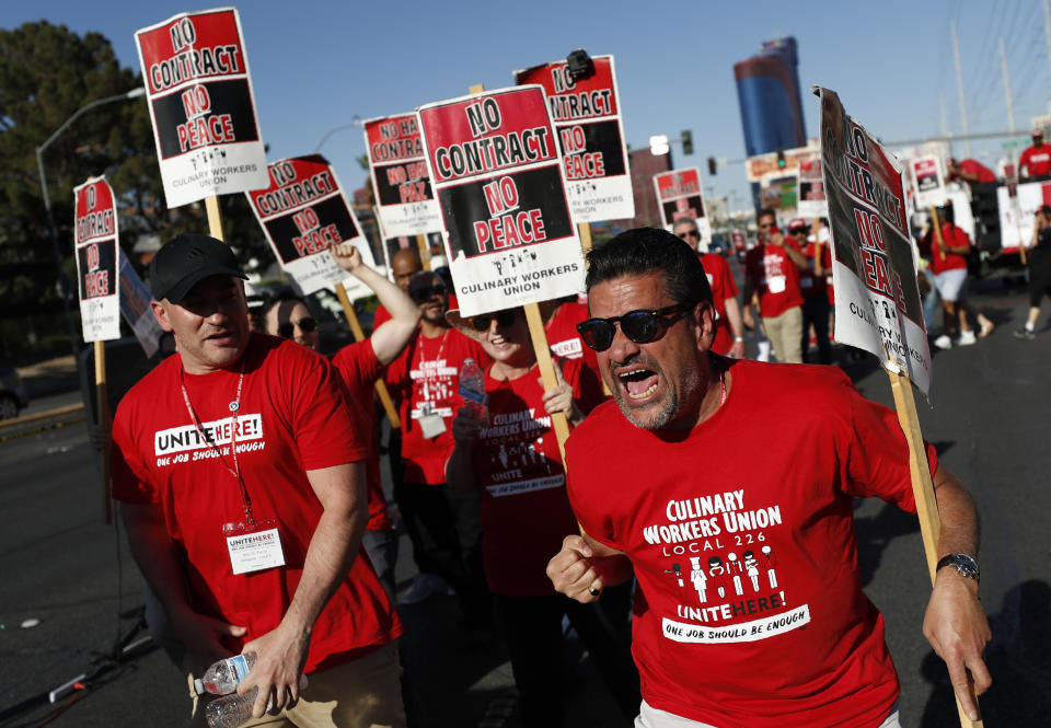 Harry Rygor, right, chants with others in front of the Palms casino-resort, Wednesday, June 26, 2019, in Las Vegas. Members of a powerful Las Vegas casino workers union and other hospitality workers picketed outside the Palms, which has refused to bargain with the union. (AP Photo/John Locher)