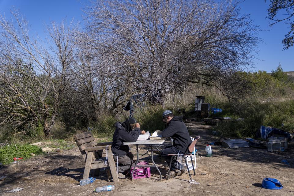 Jewish settlers study Torah at the West Bank outpost of Homesh, near the Palestinian village of Burqa, Monday, Jan. 17, 2022. Israeli settlers' ability to maintain a presence at Homesh, which was officially dismantled in 2005, is a vivid display of the power of the settler movement nearly 55 years after Israel captured the West Bank in the 1967 Mideast war. (AP Photo/Ariel Schalit)