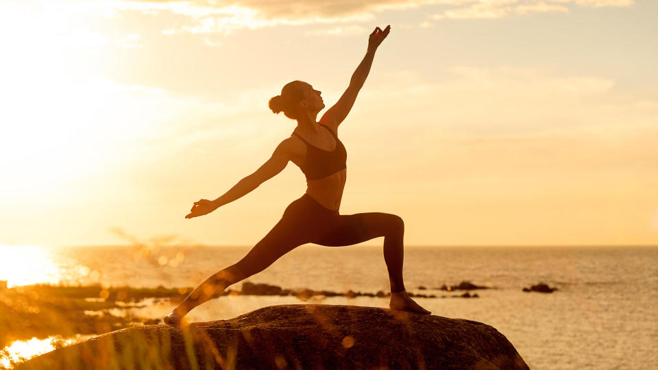 caucasian fitness woman practicing yoga at sunset.