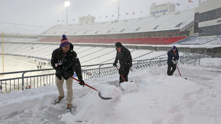 Snow is removed from the stands at Highmark Stadium before an NFL football game between the Buffalo Bills and the Miami Dolphins in Orchard Park, N.Y., Saturday, Dec. 17, 2022. (AP Photo/Joshua Bessex)