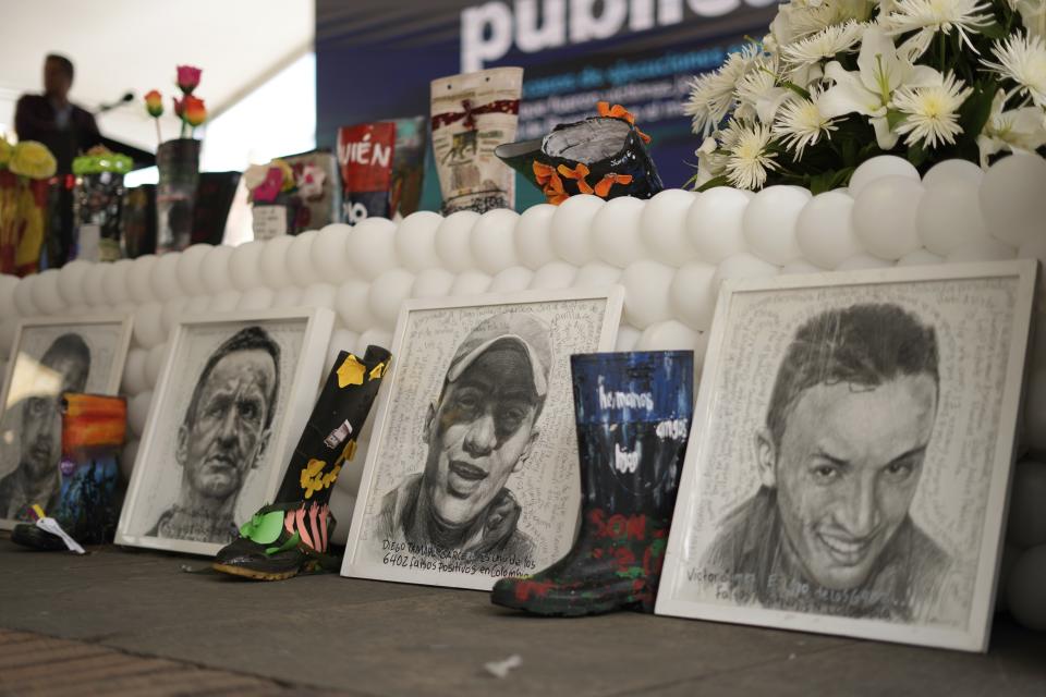 Images of the 19 young people who were falsely presented as guerrillas killed in combat by the Colombian army during the country's internal conflict, decorate a stand during an act of recognition and public apology by the state for their extrajudicial execution, in Bogota, Colombia, Tuesday, Oct. 3, 2023. (AP Photo/Fernando Vergara)