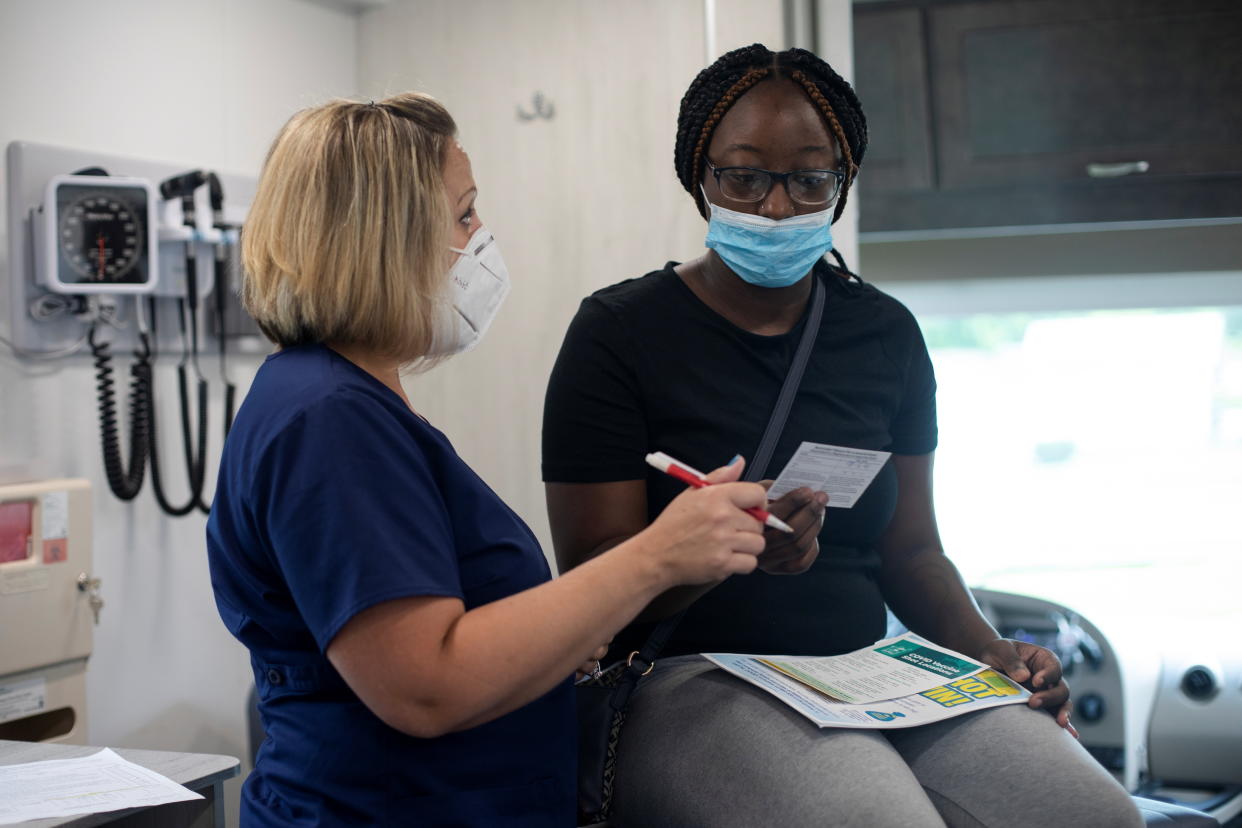 Detroit nurse Hollie Macias converses with Shanya Taylor, 19, before she receives her coronavirus vaccination.  (Emily Elconin/Reuters)