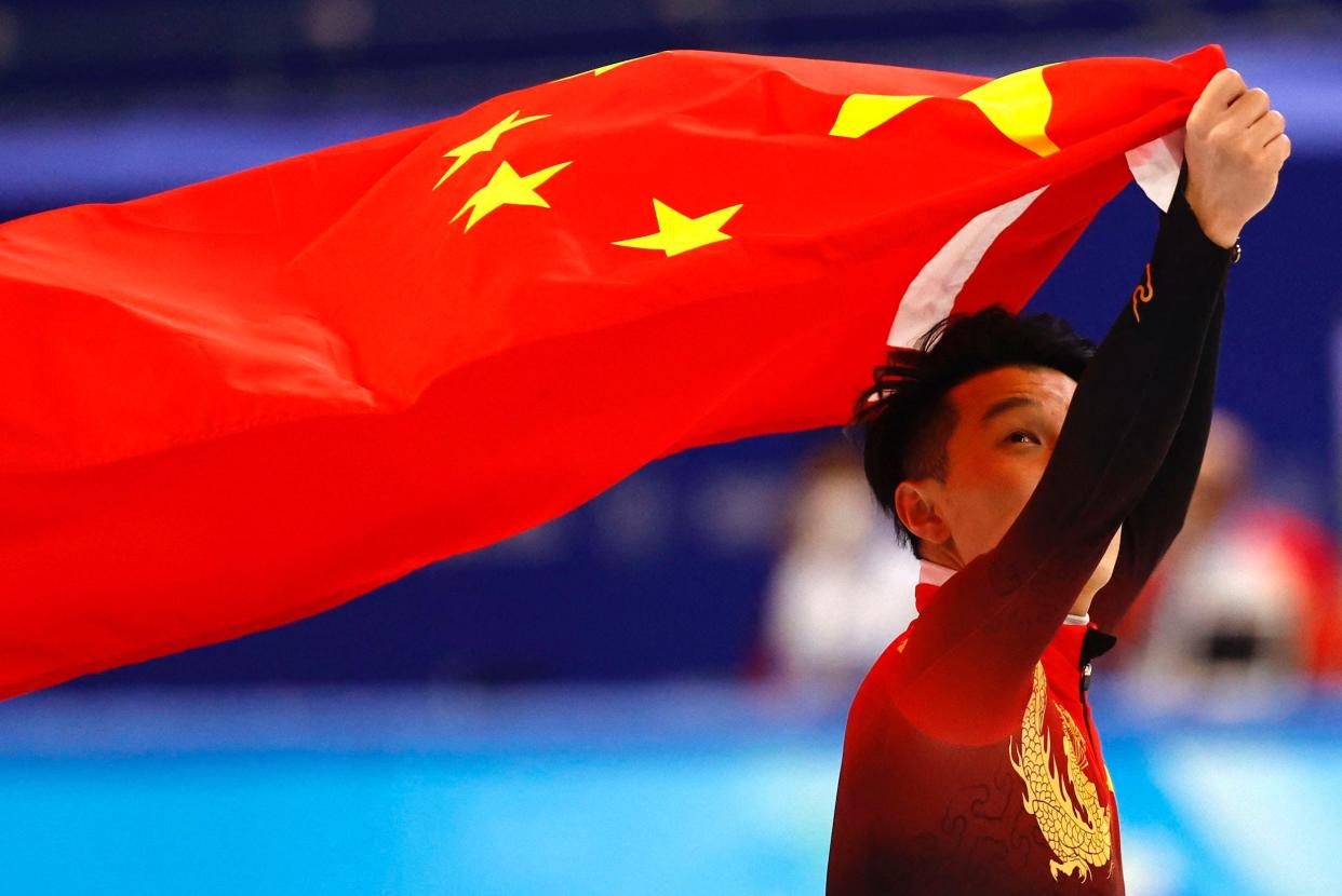 Ren Ziwei of China celebrates with the national flag of China after winning gold.