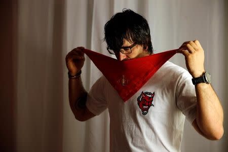 Sergio Colas puts on the scarf his father wore when he ran with the bulls as he prepares to take part in the first bull run of the San Fermin festival in Pamplona, northern Spain, July 7, 2016. REUTERS/Susana Vera