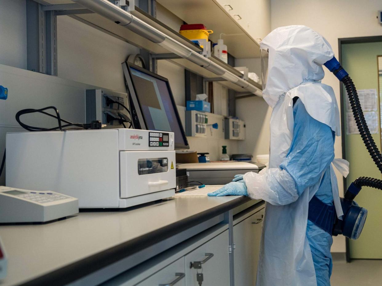 A scientist at the Helmholtz Centre for Infection Research works in a high security laboratory in Braunschweig, northern Germany, 8 May 2020: AFP via Getty Images