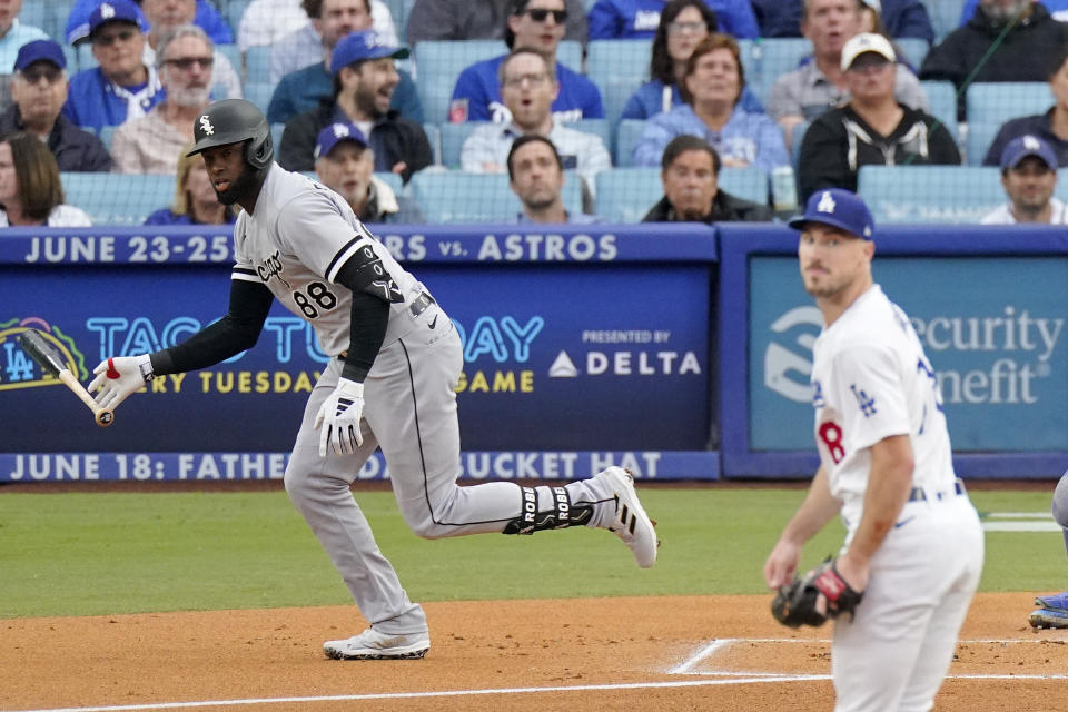 Chicago White Sox's Luis Robert Jr., left, heads to first after hitting a solo home run as Los Angeles Dodgers starting pitcher Michael Grove watches during the first inning of a baseball game Thursday, June 15, 2023, in Los Angeles. (AP Photo/Mark J. Terrill)