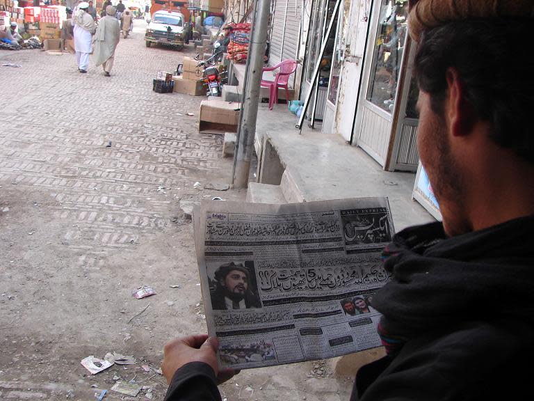 A Pakistani tribesman reads news of the killing of Taliban leader Hakimullah at a market in Miranshah, the main town in North Waziristan district on November 2, 2013