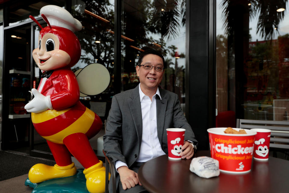 FILE PHOTO: Ernesto Tanmantiong, President and CEO of Jollibee Foods Corp., poses with Jollibee products outside a Jollibee branch in Pasig City, Metro Manila, Philippines, July 30, 2019. REUTERS/Eloisa Lopez