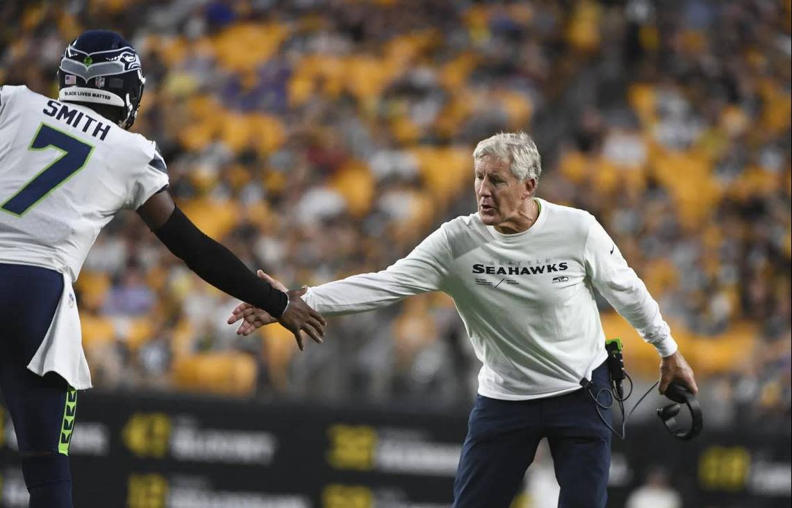 Coach Pete Carroll congratulates quarterback Geno Smith during his 2-minute drive to a touchdown late in the first half of the Seahawks’ preseason game at Pittsburgh Saturday night.