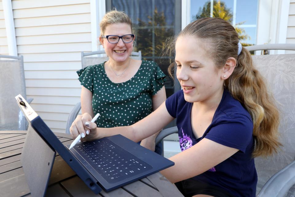 Stacy Brodsky looks on as her daughter Alice, 12, works on an assignment at home in White Plains, N.Y., on Oct. 8, 2020. Brodsky gave up her job of six years teaching pre-K during the pandemic to stay home for her children, ages 12 and 9, who are on hybrid school schedules. Her husband is also a teacher and she feels lucky that she can stay home, but feels stripped of an entire identity.