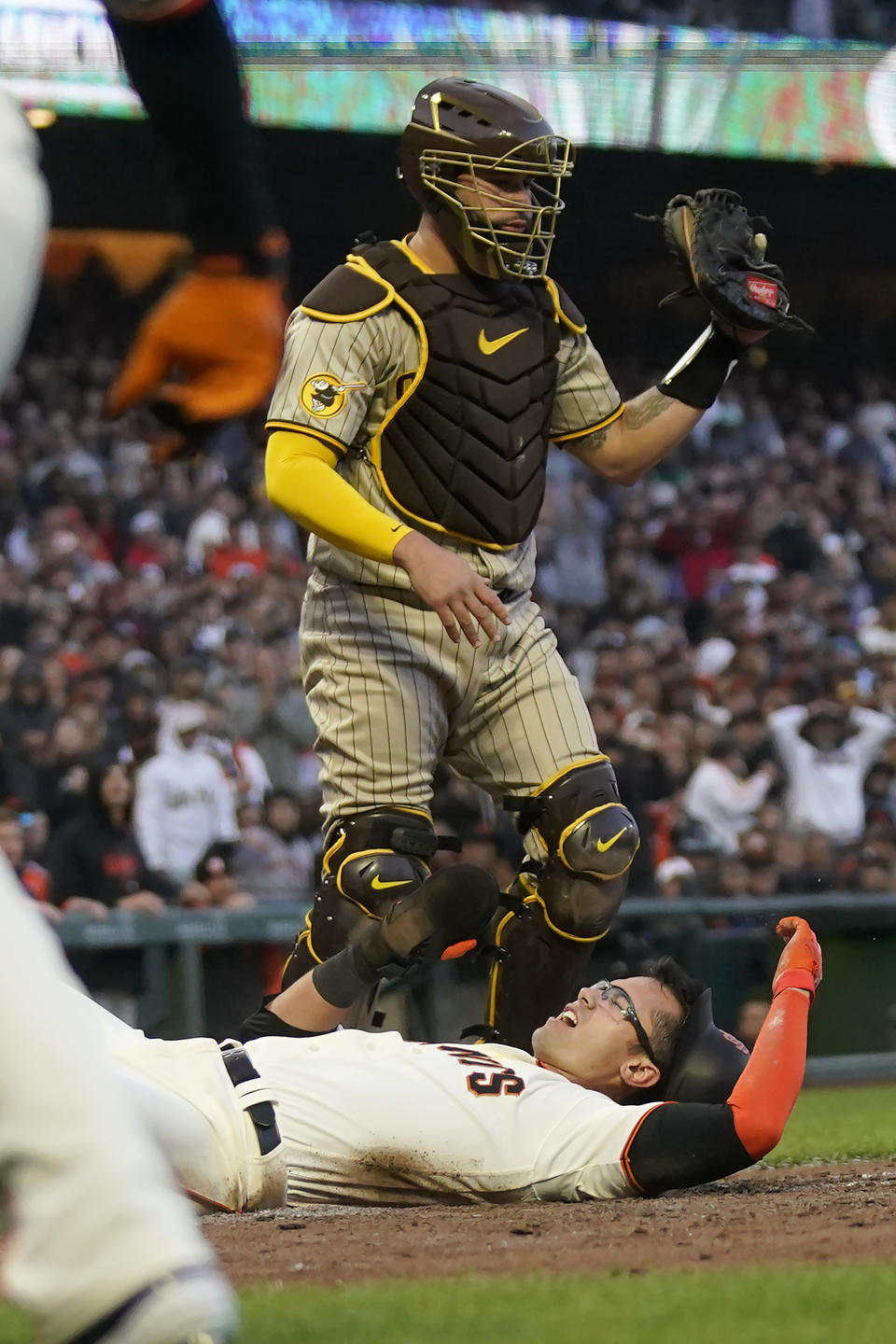 San Francisco Giants' Blake Sabol, bottom, reacts after scoring against San Diego Padres catcher Gary Sanchez, top, during the fifth inning of a baseball game in San Francisco, Wednesday, June 21, 2023. Sabol was initially called out but was ruled safe after the Giants challenged the call. (AP Photo/Jeff Chiu)