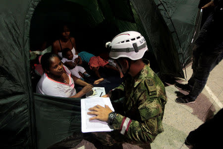 A soldier speaks to people resting in a tent at the municipal coliseum after the Colombian government ordered the evacuation of residents living along the Cauca river, as construction problems at a hydroelectric dam prompted fears of massive flooding, in Valdivia, Colombia May 17, 2018. REUTERS/Fredy Builes