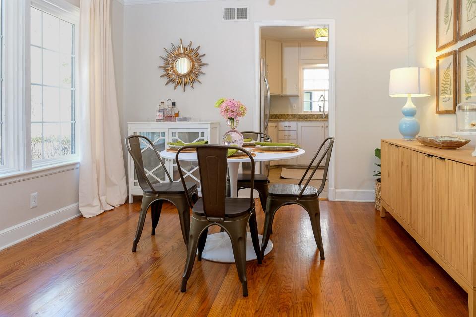 The dining area features plenty of built-in storage. It is brightly lit with a wall of large windows looking out onto the front of the home.