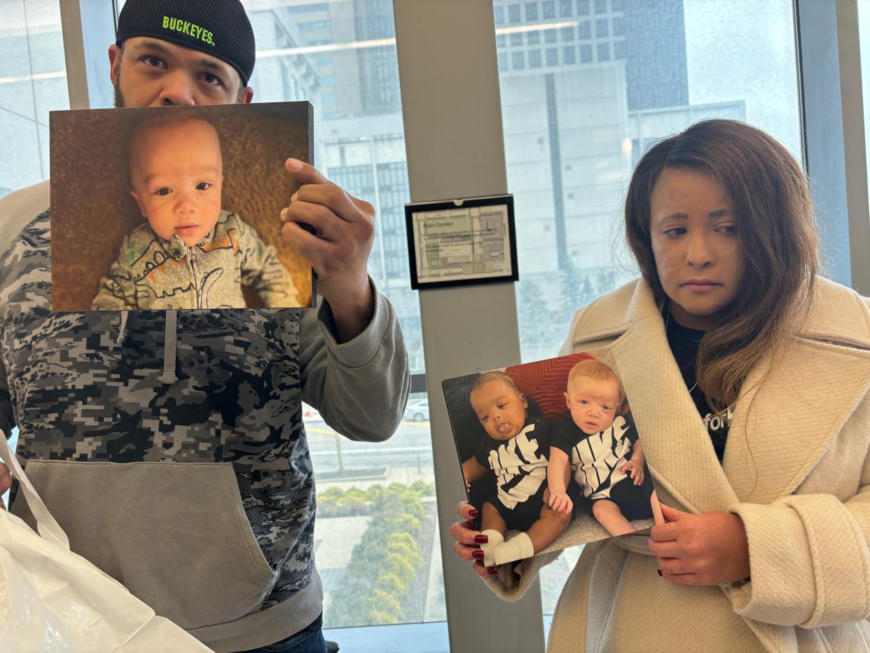 Jontue Chatman and Stacia Crawford hold up photos of their infant son, Kashan Roman Crawford-Chatman, in Franklin County Common Pleas Court after the arraignment Wednesday, Feb. 28, 2024, of Tammra Straughter, a Reynoldsburg home day care operator who is accused of shaking the baby to death in October 2023.