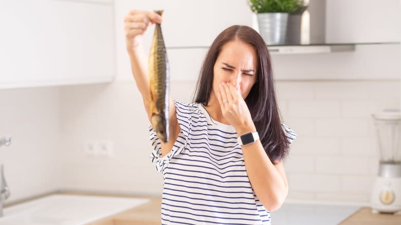 woman holding smelly fish 