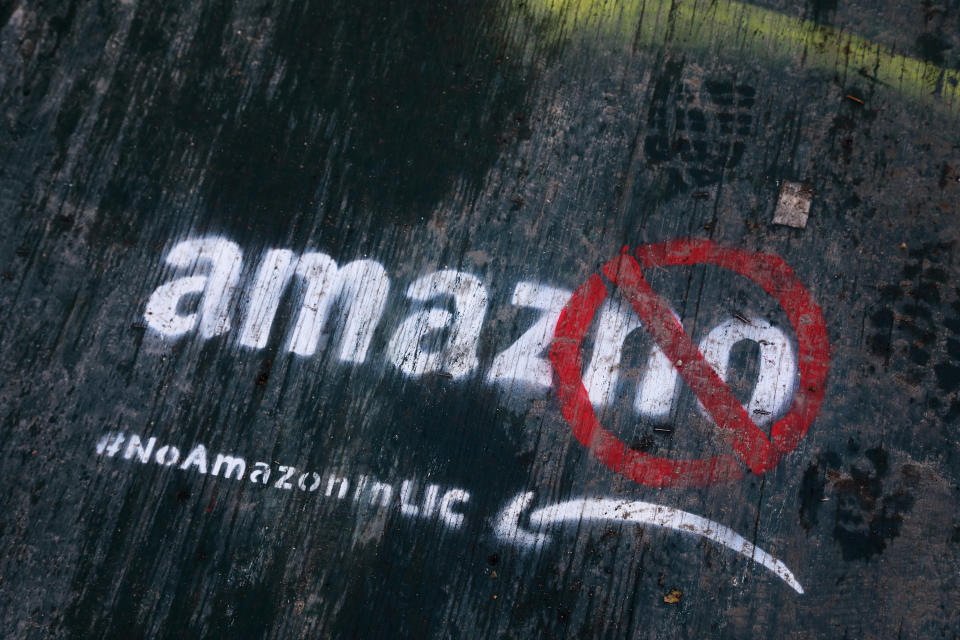 Graffiti has been painted on a sidewalk by someone opposed to the location of an Amazon headquarters in the Long Island City neighborhood in the Queens borough of New York, Friday, Nov. 16, 2018.  Residents of the New York City public housing complex near the spot where Amazon plans to put a new headquarters have mixed reaction to the global behemoth coming to the neighborhood. (AP Photo/Mark Lennihan)