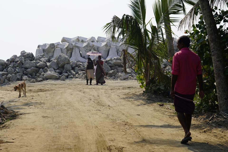 Two women walk near part of the new sea wall in Kochi, Kerala state, India, March 4, 2023. Tens of millions of people in India live along coastlines and thus are exposed to major weather events. One common adaptation technique, in India and other countries hit hard by rising seas and oceanic storms, is to build sea walls. (AP Photo)