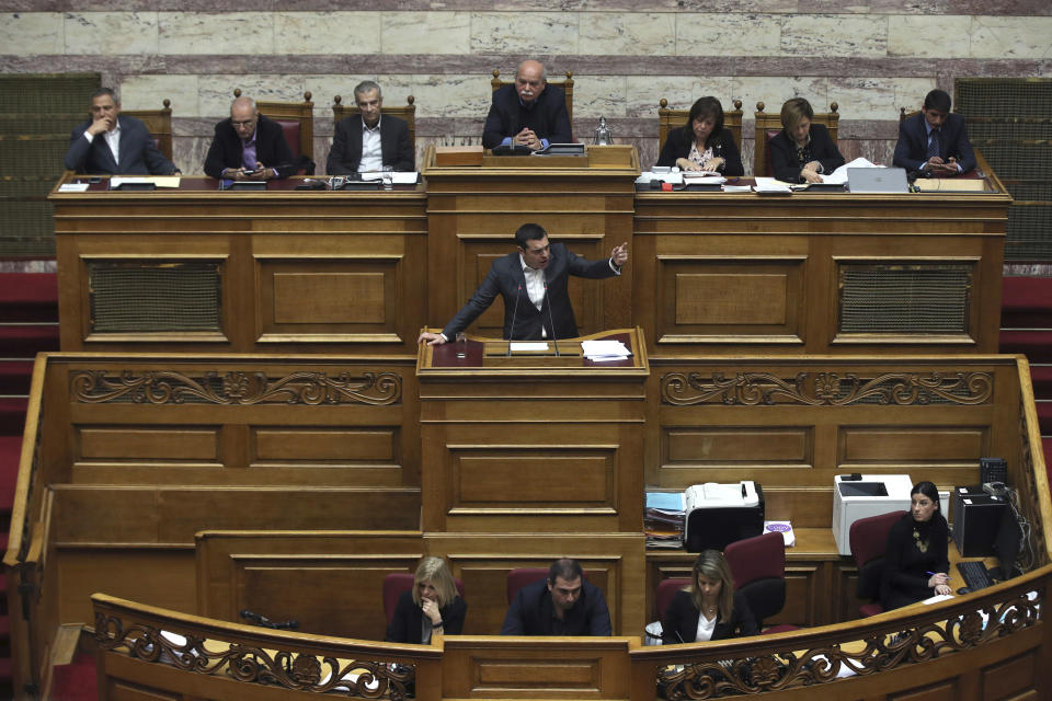 Greek Prime Minister Alexis Tsipras, center, speaks during a parliamentary session in Athens, on Tuesday, Jan. 15, 2019. Greece's prime minister is defending his deal to normalize relations with neighboring Macedonia ahead of a confidence vote in parliament after his governing coalition collapsed over the agreement. (AP Photo/Petros Giannakouris)