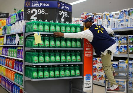 A worker sets up a display of dish washing liquid in prepare for the opening of a Walmart Super Center in Compton, California