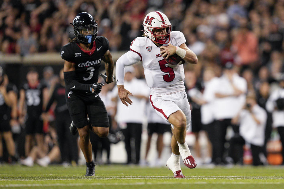 Miami (Ohio) quarterback Brett Gabbert (5) runs as Cincinnati safety Deshawn Pace (3) defends during the first half of an NCAA college football game, Saturday, Sept. 16, 2023, in Cincinnati. (AP Photo/Jeff Dean)