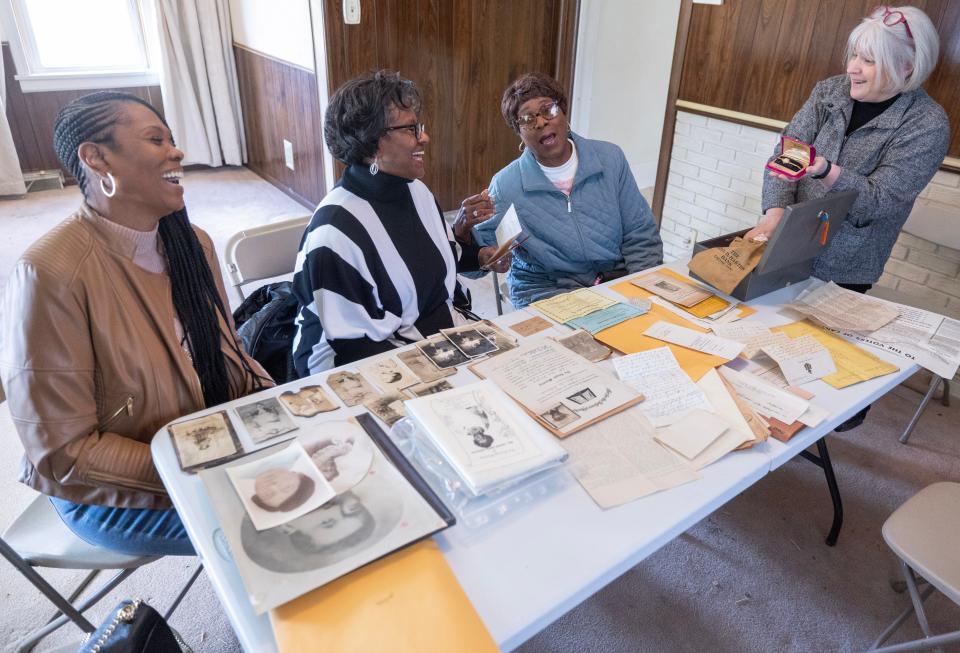 Beth Lechner, CEO of Habitat for Humanity East Central Ohio, far right, presents family memorabilia to Kim Manley, left, Deborah Johnson-Graham, center, and Marie Justice, that was found hidden away in the Johnson family home in Canton.