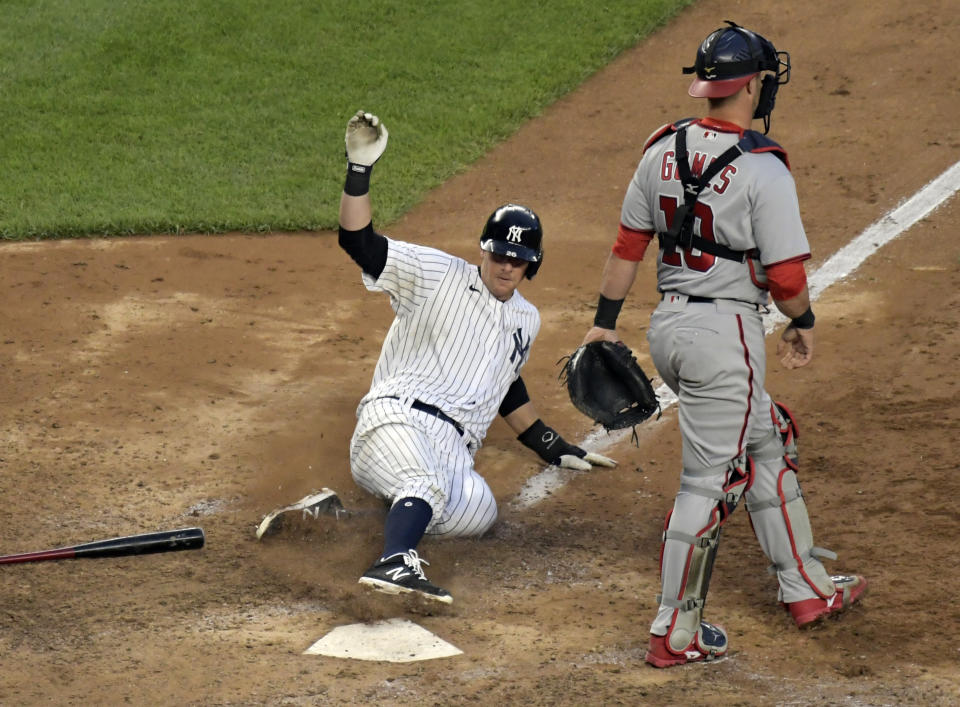 New York Yankees' DJ LeMahieu scores the winning run on an infield single by Gleyber Torres as Washington Nationals catcher Yan Gomes (10) walks away in the 11th inning of a baseball game, Saturday, May 8, 2021, at Yankee Stadium in New York. The Yankees won 4-3. (AP Photo/Bill Kostroun)