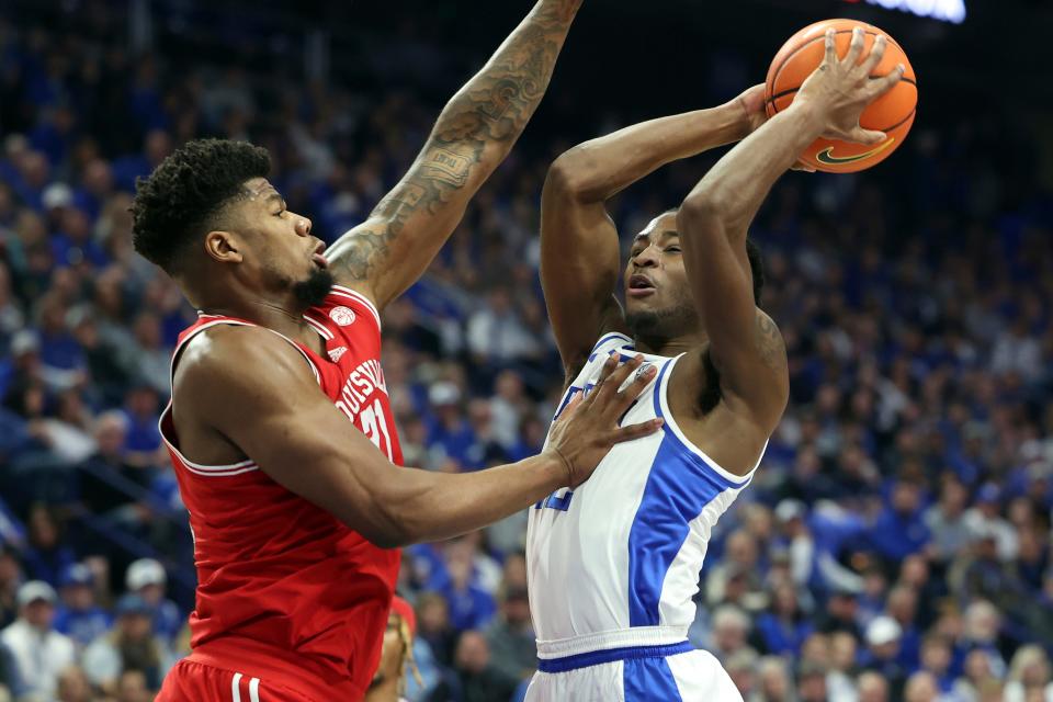 Kentucky's Cason Wallace (22) shoots while pressured by Louisville's Sydney Curry (21) during the first half of an NCAA college basketball game in Lexington, Ky., Saturday, Dec. 31, 2022. (AP Photo/James Crisp)