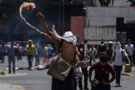 <p>Un manifestante opositor se enfrenta a integrantes de la Policía Nacional Bolivariana (PNB) durante una manifestación hoy, martes 4 de abril de 2017, que intentaba marchar hacia el Parlamento en apoyo a la destitución de los magistrados del Supremo, en Caracas (Venezuela). La Guardia Nacional Bolivariana de Venezuela (GNB, policía militar) disolvió hoy con gases lacrimógenos y perdigones de goma una manifestación de decenas de opositores que intentaban marchar hacia el Parlamento en apoyo a la destitución de los magistrados del Supremo, según constató Efe. EFE/CRISTIAN HERNÁNDEZ </p>