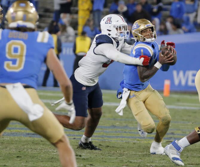 PASADENA, CALIF. NOV. 12, 2022. iUCLA quarterback Dorian Thompson-Robinson gets pulled down.