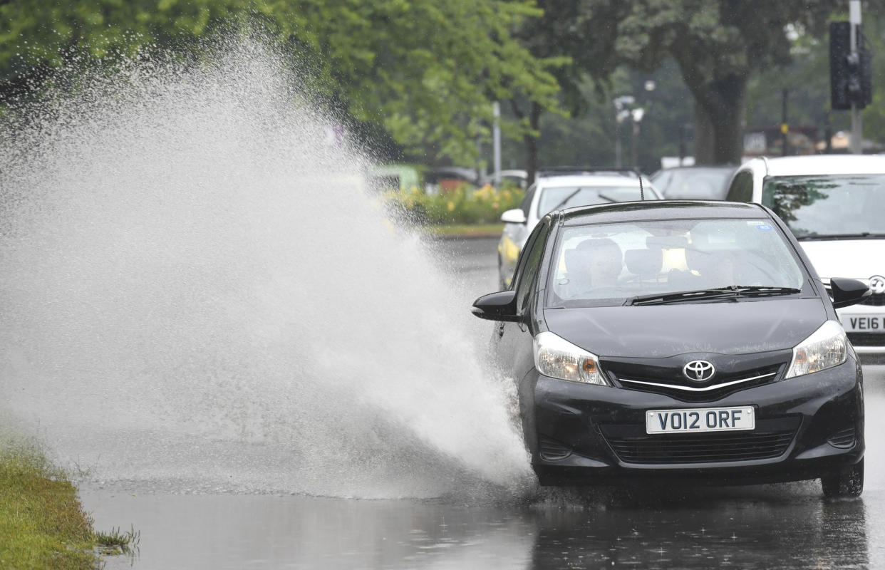 A car is driven through a puddle in Birmingham, England, as the weather across the UK changes with the arrival of Storm Miguel, Friday June 7, 2019.  Periods of diluvial rains are inflicting localised flooding in some areas across the country. (Jacob King/PA Wire( / PA via AP)