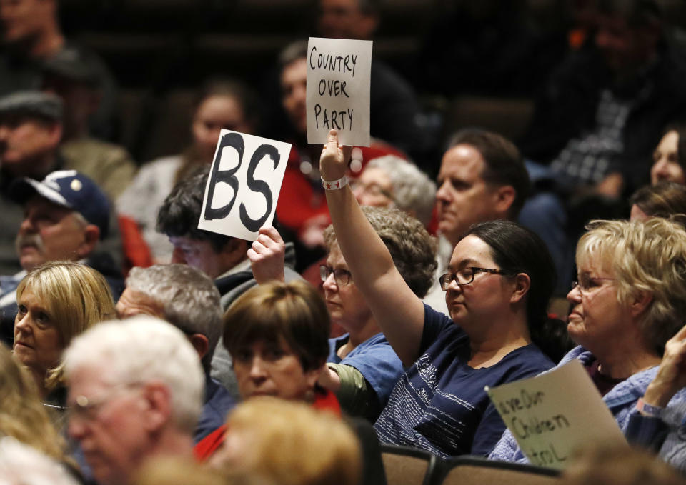 <p>Protesters hold up sign as U.S. Rep. Mike Coffman, R-Colorado, talks during a town hall meeting with constituents in a high school assembly hall Tuesday, Feb. 20, 2018, in Greenwood Village, Colo. Coffman was peppered with questions about gun control in the wake of the mass shooting at a school in south Florida last week. (Photo: David Zalubowski/AP) </p>