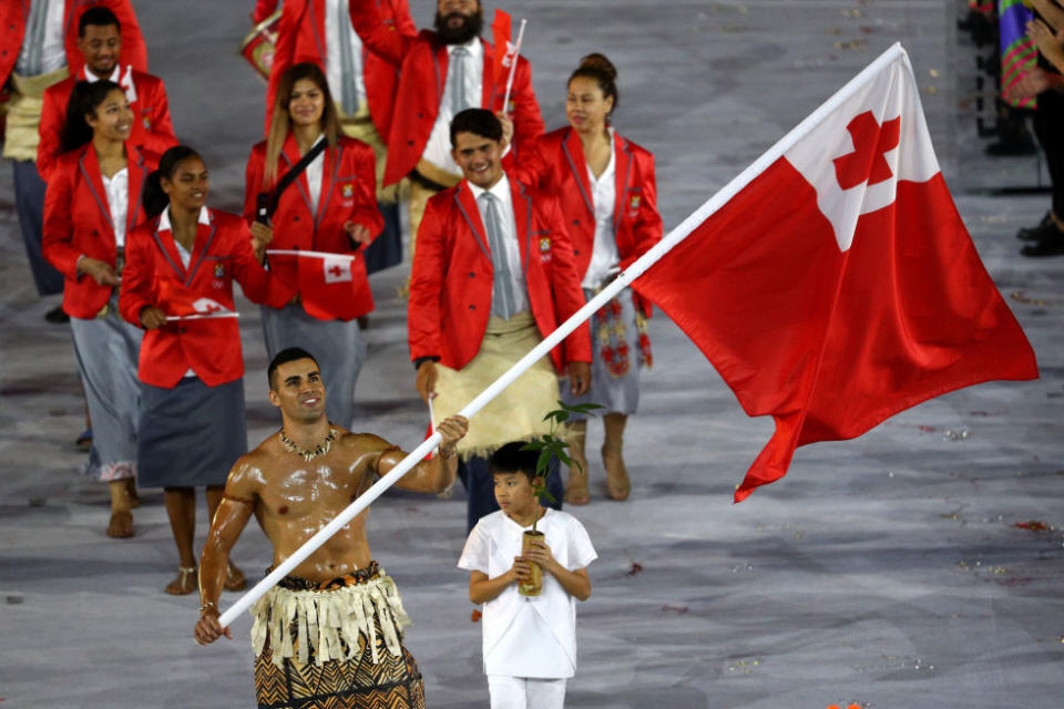 Pita Nikolas Aufatofua of Tonga bears his nation’s flag (and sets off the Internet swooning).