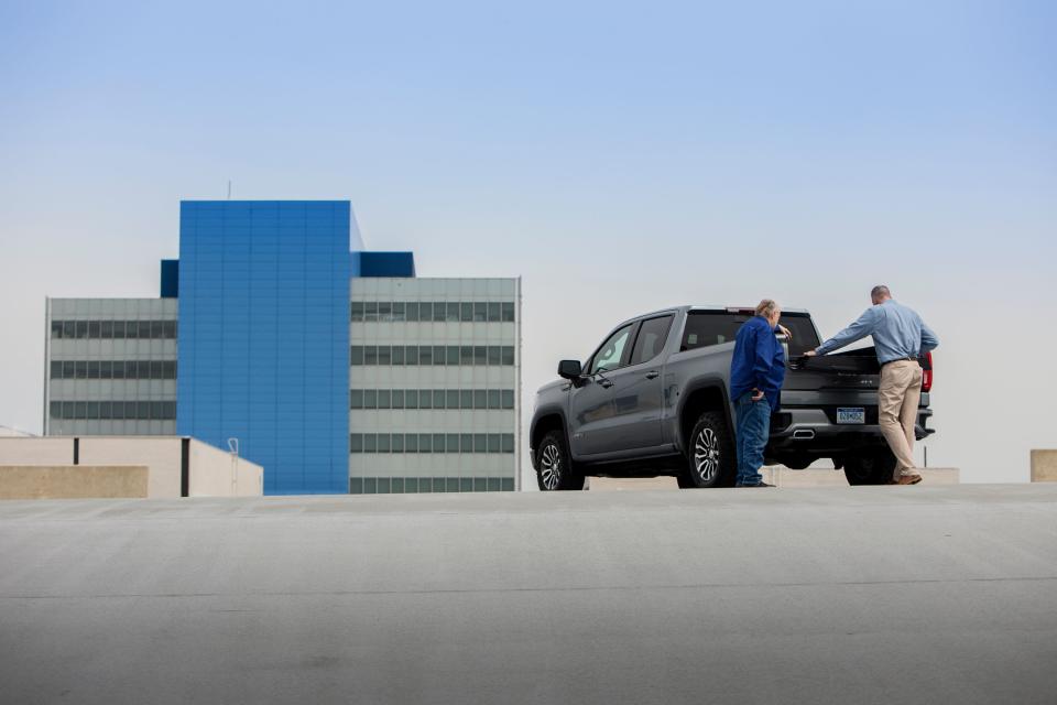 Jim Gobart, GM engineering technician and Derek Patterson, lead integration engineer for Multipro System  tinker with the GMC Sierra MultiPro tailgate, seen here at the GM Vehicle Engineering Center in Warren., Mich., Thursday, May 16, 2019. The concept began with the two men talking to workers about what they want and need in a truck and this is the first time he's checked it out on a production vehicle.