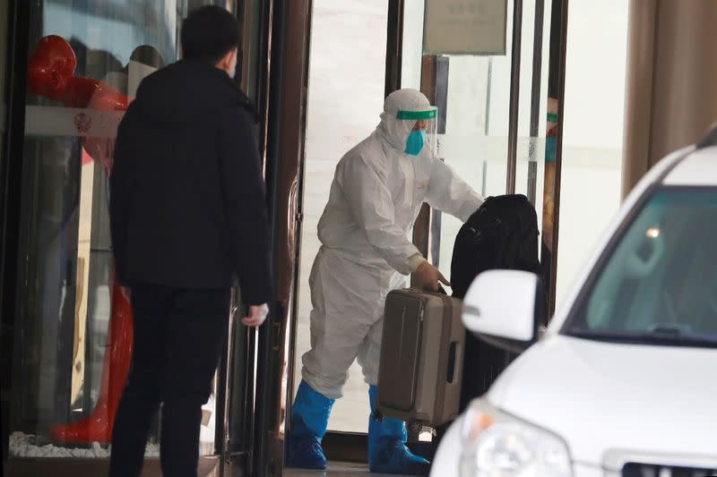 WHO team members tasked with investigating the origins of the coronavirus disease (COVID-19) pandemic leave their quarantine hotel in Wuhan