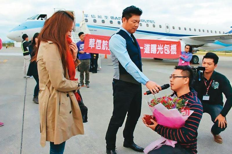 吳昭輝（右2）5年前精心安排浪漫求婚，帶著當時還是女友的妻子（左）搭乘曙光專機，在停機坪單膝下跪求婚，愛情故事還登上報紙頭版。（華信航空提供）