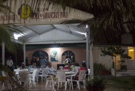 Clients sit at a state-run restaurant decorated with a photograph of Cuba's former President Fidel Castro in Havana January 17, 2015. REUTERS/Alexandre Meneghini