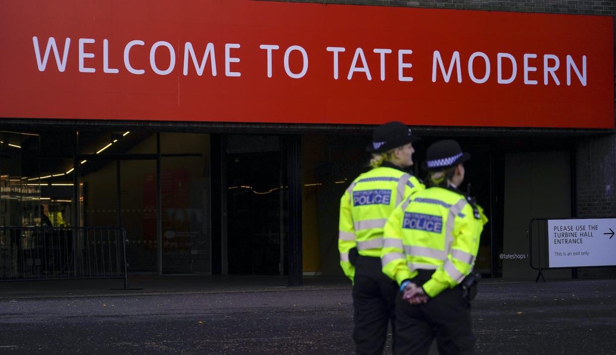 Police officers patrol the entrance of the Tate Modern gallery, in London, Oct. 15, 2022, after climate protesters threw soup over glass covering Vincent van Gogh's 'Sunflowers' in London's National Gallery. (AP Photo/Alberto Pezzali)